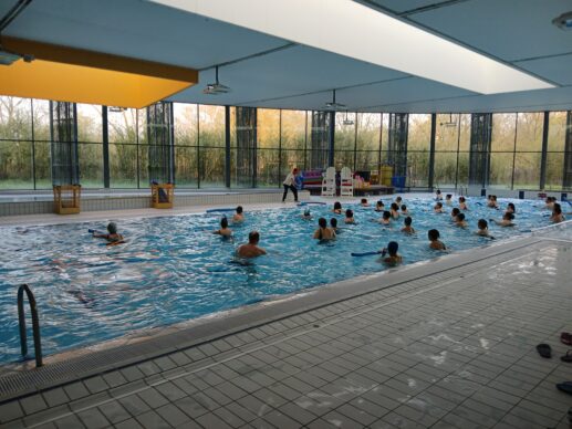 Groupe de personne dans une piscine faisant de l'aquagym lors de l'événement Aquanight.